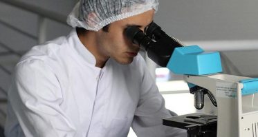 Scientist looking through microscope